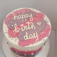 a happy birthday cake with pink and purple frosting