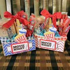 two baskets filled with movie tickets and candy on top of a checkered table cloth