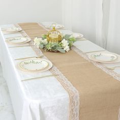 the table is set with place settings and flowers on it for an elegant dinner party