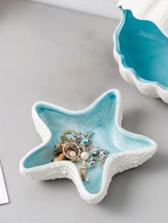 two star shaped dishes with rings in them on a table next to a white wall