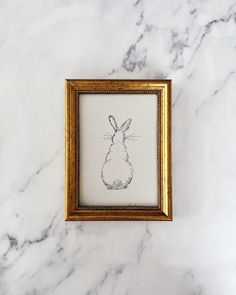 a drawing of a chicken in a frame on a marble surface