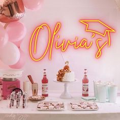 a table topped with cakes and desserts under a neon sign that says ohirjaf