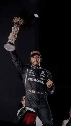 a man holding up a trophy in the air