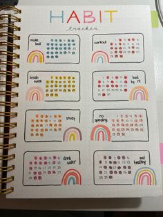 a planner with rainbows on it and the words habit written in different languages next to a calculator