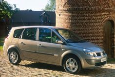 a silver car parked in front of a brick building