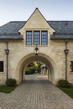 an arched stone building with a brick walkway leading to it