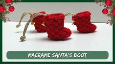 two red crocheted booties are hanging from a rope on a white table