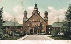 an old postcard shows the front entrance to a large brick building with two towers