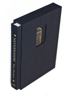 a black book with gold foil on the front and back cover is open to show an image of a window