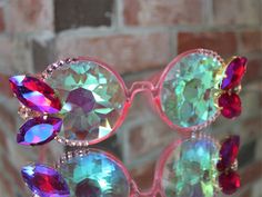 ADULT sized new circle frame lightshow funglasses with kaleidoscope lens, decorated with big fancy glass rhinestones. These glasses have a fantastic shine in the sunlight, but are also incredible as a nighttime concert accessory. The kaleidoscope glass creates spectacular patterns when looking at a lightshow. *Please note, this pair is somewhat heavy due to the kaleidoscope glass* *Not to be used as sunglasses; these offer no UV protection* **NOT RECOMMENDED IF YOU GET MOTION SICKNESS** Custom c Kaleidoscope Glasses, Motion Sickness, Circle Frame, Circle Frames, Faceted Glass, Light Show, Eyewear Sunglasses, Crystal Rhinestone, Sunglasses Accessories