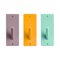 three different colored handles on the same wall and one is yellow, green, blue, pink