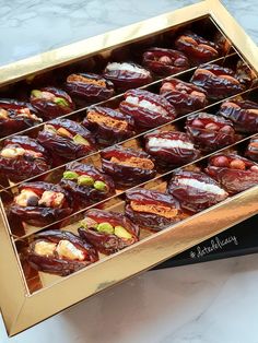 a box filled with lots of different types of pastries on top of a table