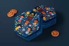 two blue tins with cookies on them and one cookie in the shape of a hexagonal box