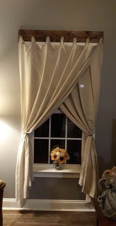 the sunflowers are sitting on the window sill in the room with the curtains pulled back