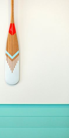 a wooden paddle mounted to the side of a wall next to a blue painted wall