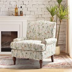 a chair sitting in front of a fireplace with a potted plant next to it