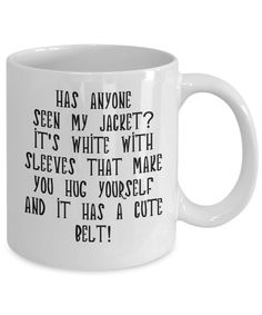 a white coffee mug with the words, has anyone seen my jacket? it's white with sleeves that make you hug yourself and it has a cute belt