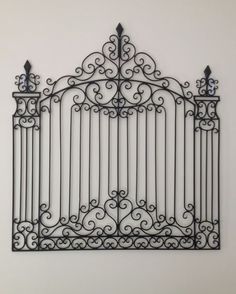 a wrought iron gate with two birds on it's top and the bottom bars