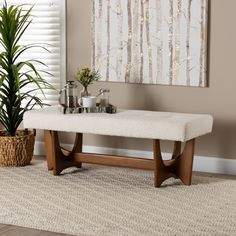 a white bench sitting in front of a window next to a potted plant on top of a rug