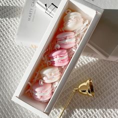 a box filled with pink and white donuts next to a gold trophy on top of a table