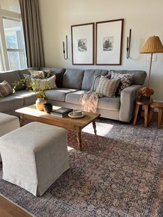 a living room filled with furniture and pillows on top of a carpeted floor next to a window