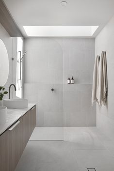 a white bathroom with two sinks and a shower