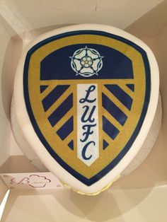 there is a cake in the shape of a shield with an emblem on it that says,