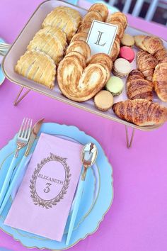 a table topped with plates and trays filled with pastries