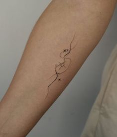 a woman's arm with a tattoo on it that has an arrow and stars