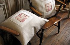 two white pillows sitting on top of a wooden chair