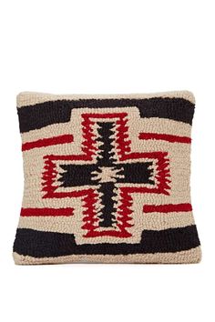 a black and white pillow with red stripes on the front, and a cross design on the back