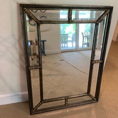 a large mirror sitting on top of a carpeted floor