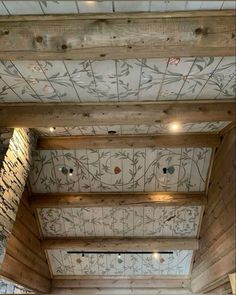 the ceiling is decorated with floral designs and wood planks, along with decorative wallpaper