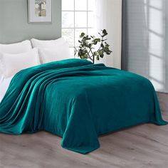 a bed covered in a teal colored blanket