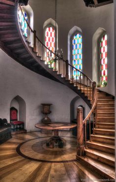 the inside of a church with stained glass windows and wooden stairs leading up to an altar