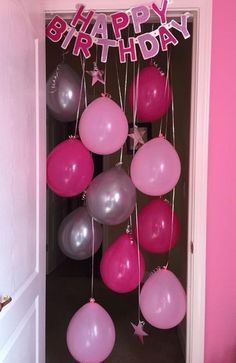 pink and silver balloons are hanging from the ceiling