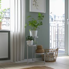 there is a potted plant next to a small table with a basket on it