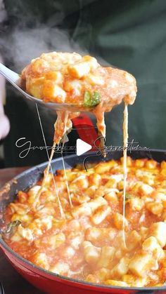 a person is spooning some food out of a skillet