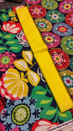 two different colored fabrics laying next to each other on a tablecloth covered with flowers