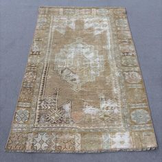 an old rug is laying on the floor in front of a gray background with white and blue accents