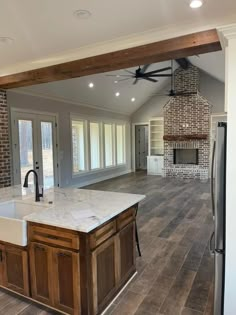 a kitchen with an island in the middle and a ceiling fan hanging from the ceiling