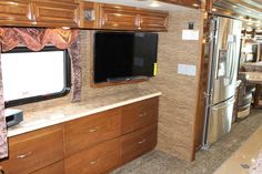 a kitchen area with a television and refrigerator