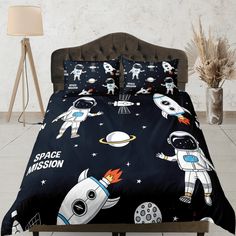 a bed with an astronaut themed comforter and pillows