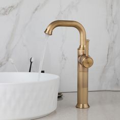 a faucet that is sitting next to a white bowl on a counter top