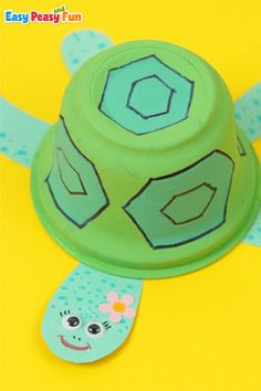 a green plastic toy with a turtle design on it's face and the words easy peasy fun