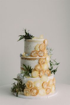 a three tiered cake decorated with flowers and leaves