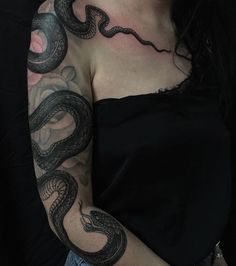 a woman with a snake tattoo on her arm