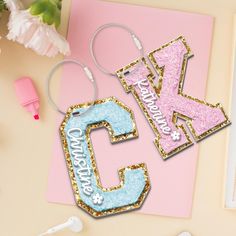 two personalized keychains with the letter k and number 5 on them next to flowers