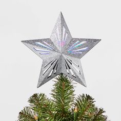 a silver star ornament on top of a christmas tree