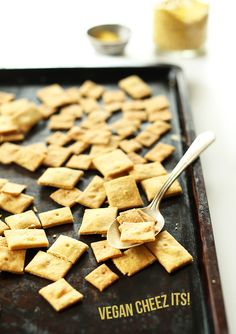 a tray filled with crackers sitting on top of a table next to a spoon